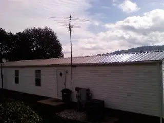 New metal roof on a single wide mobile home with a TV antenna in Dunkirk